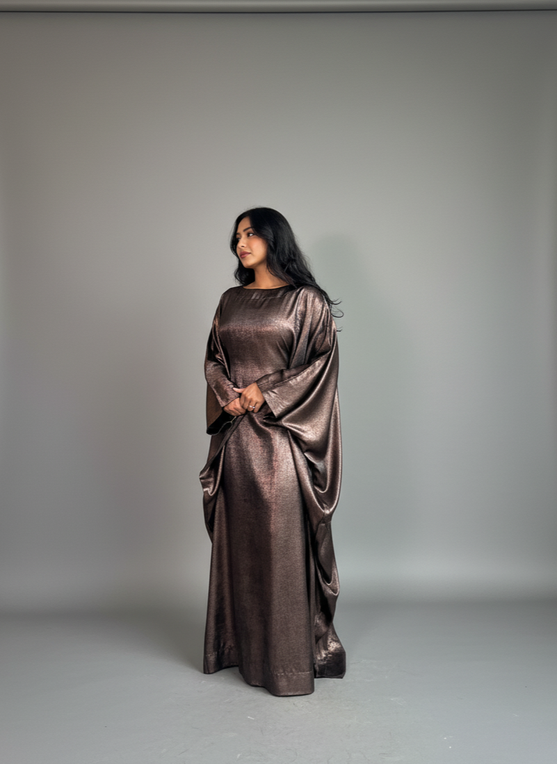 Woman wearing a metallic dress against a plain background