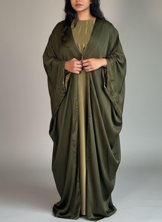 Woman wearing an olive green abaya on a plain background