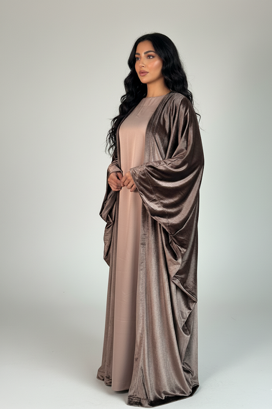 Woman wearing a long, flowing dress with a matching shawl on a white background