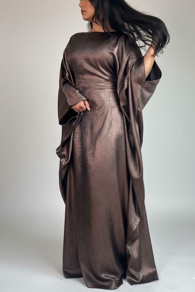 Woman wearing a metallic brown dress against a white background